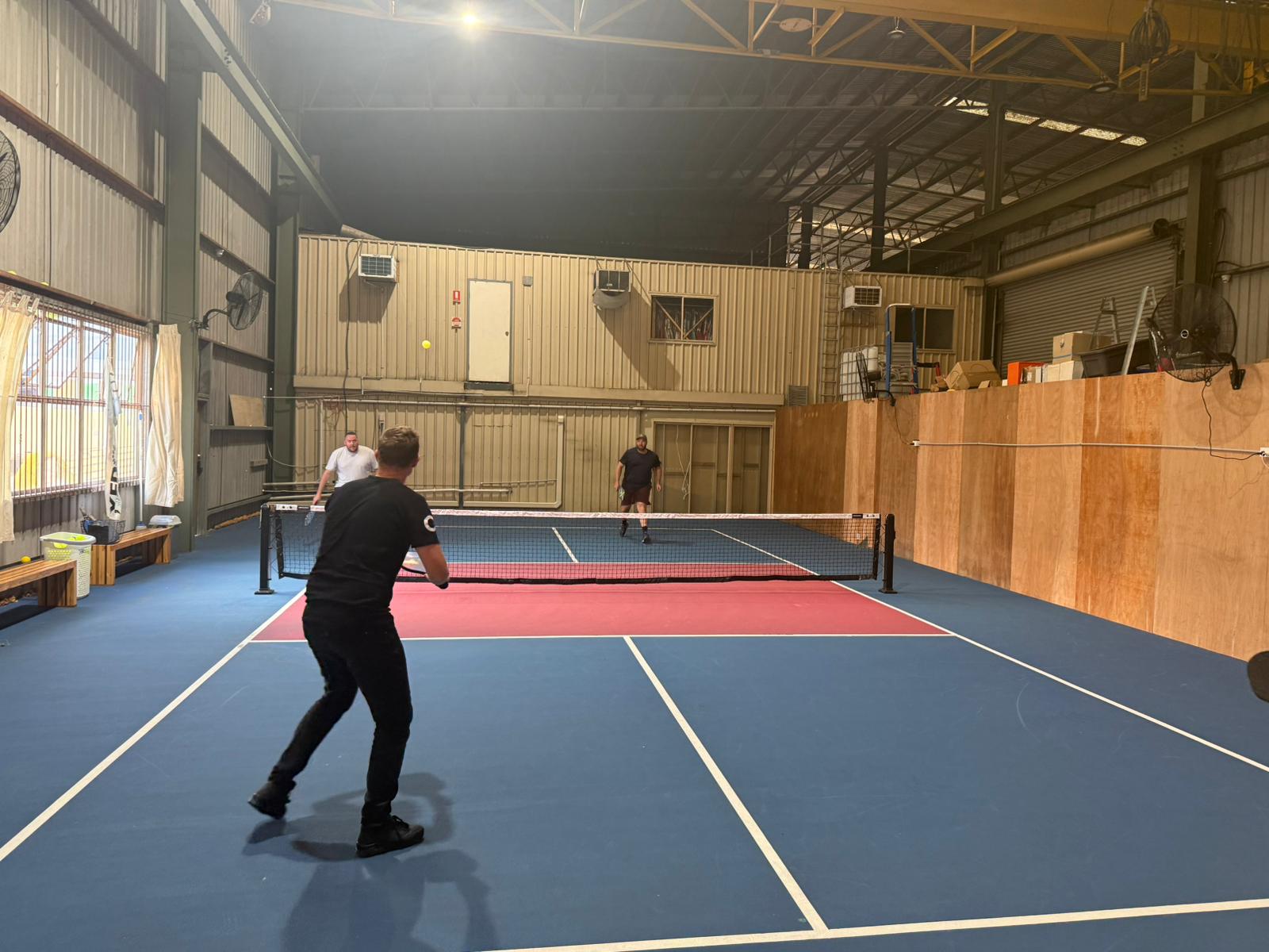 Pickleball match in a converted warehouse-style indoor venue